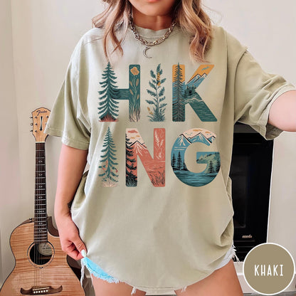 Comfort Colors tee in Khaki featuring nature graphic with trees and mountains inside the word Hiking