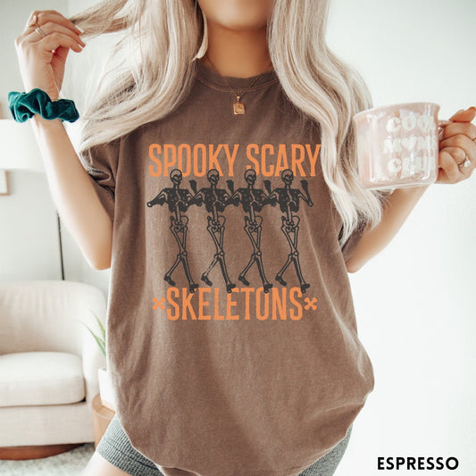 Comfort Colors tee in Espresso featuring dancing skeletons graphic with Spooky Scary Skeletons text in orange
