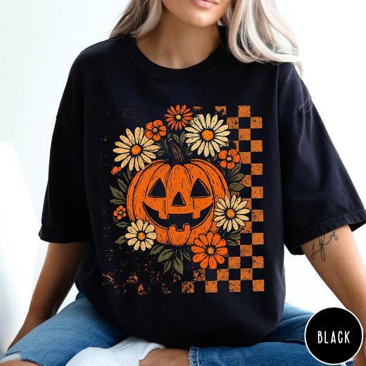 Comfort Colors tee in Black featuring retro floral jack-o'-lantern graphic with a checkered pattern side design