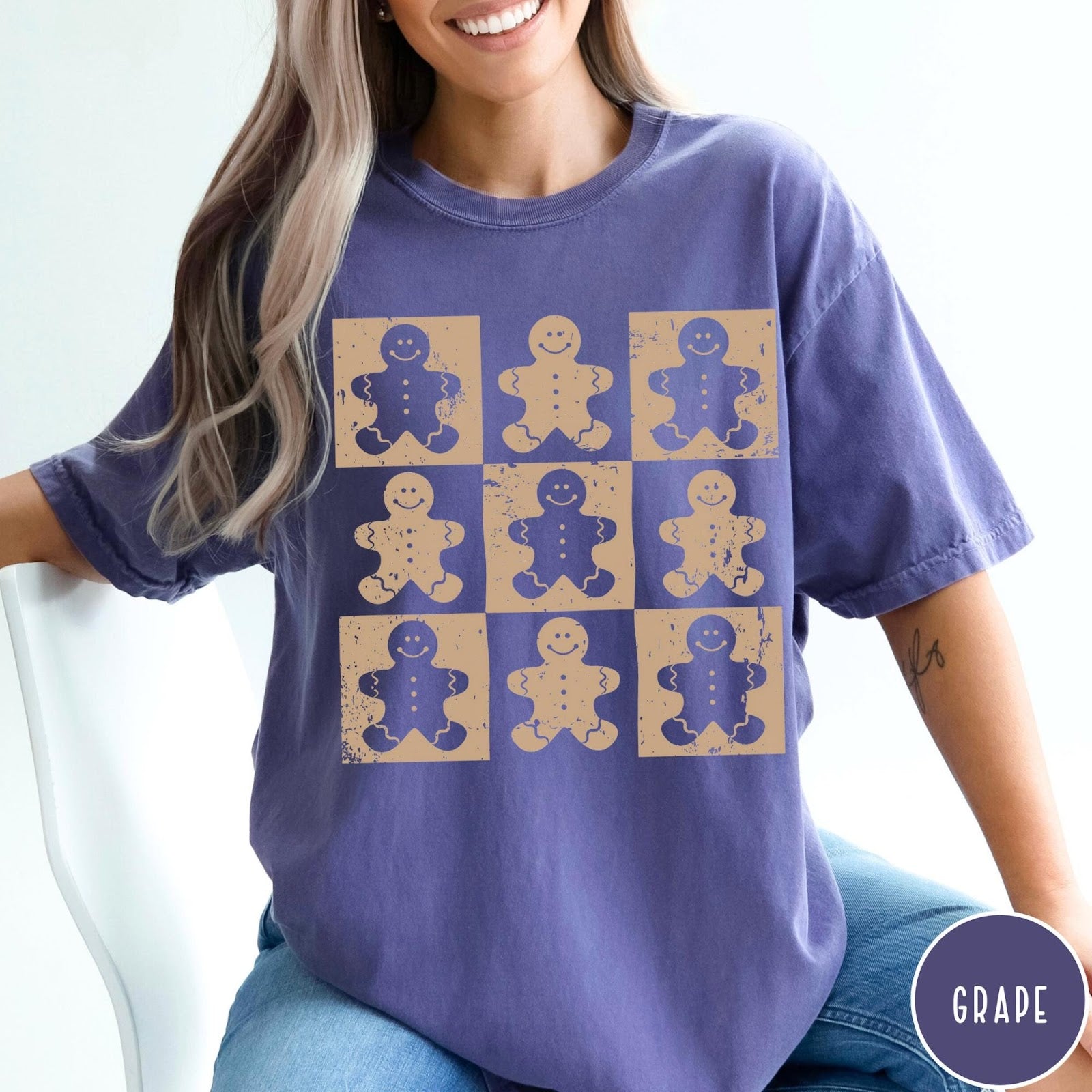Comfort Colors tee in Grape featuring distressed graphic design with nine square panels of smiling gingerbread cookie figures