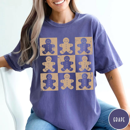 Comfort Colors tee in Grape featuring distressed graphic design with nine square panels of smiling gingerbread cookie figures