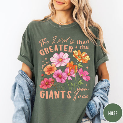 Comfort Colors tee in Moss featuring floral Bible verse graphic design with 1 John 4:4 scripture text