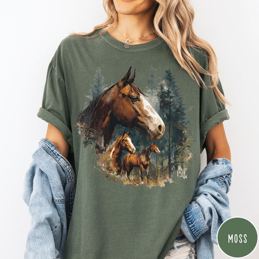 Comfort Colors tee in Moss featuring vintage style graphic of three horses standing in a pine forest