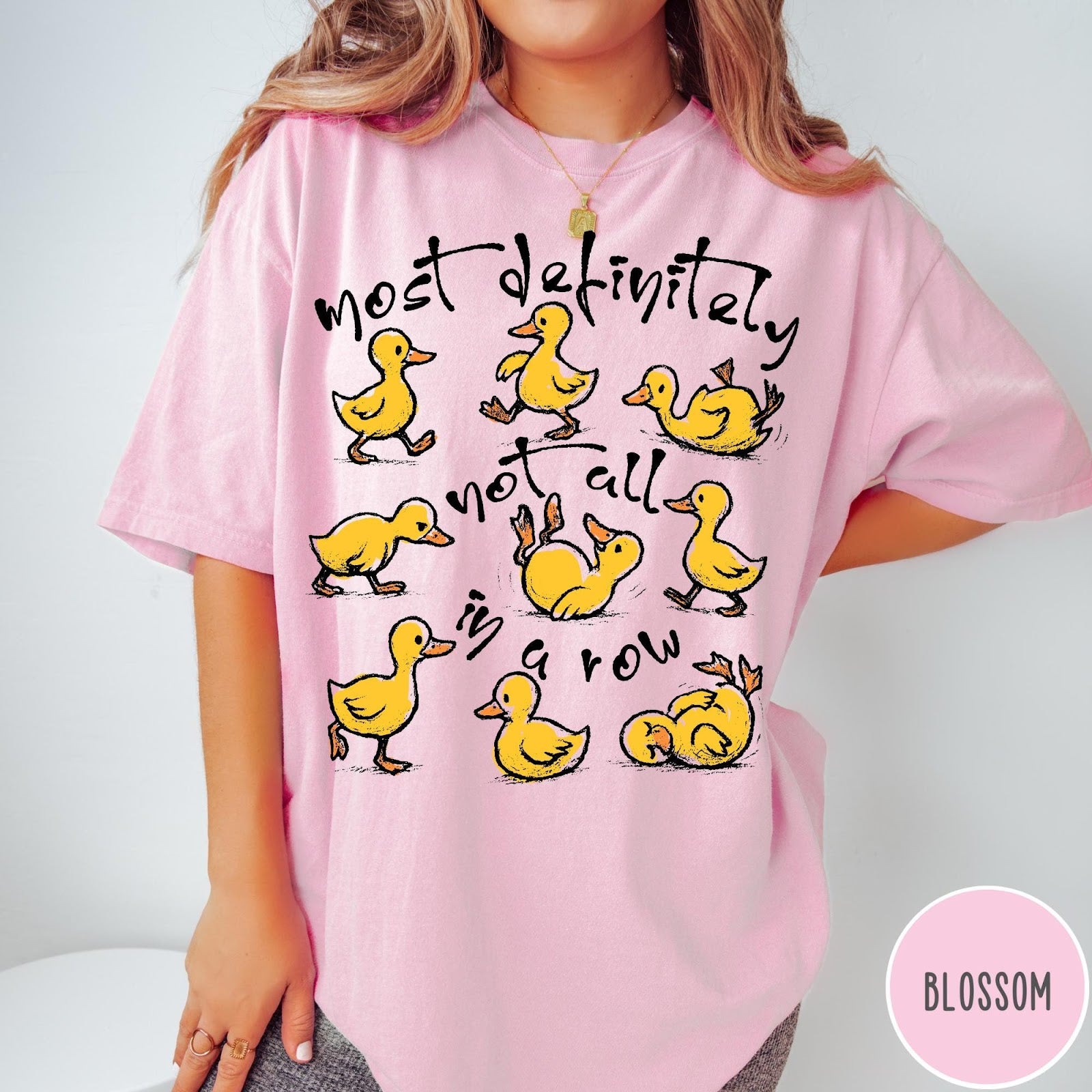 Comfort Colors tee in Blossom featuring whimsical duck graphic with text most definitely not all in a row.