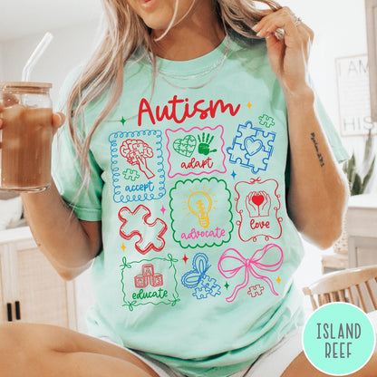 Comfort Colors tee in Island Reef featuring coquette style autism awareness graphic with puzzle pieces and colorful icons