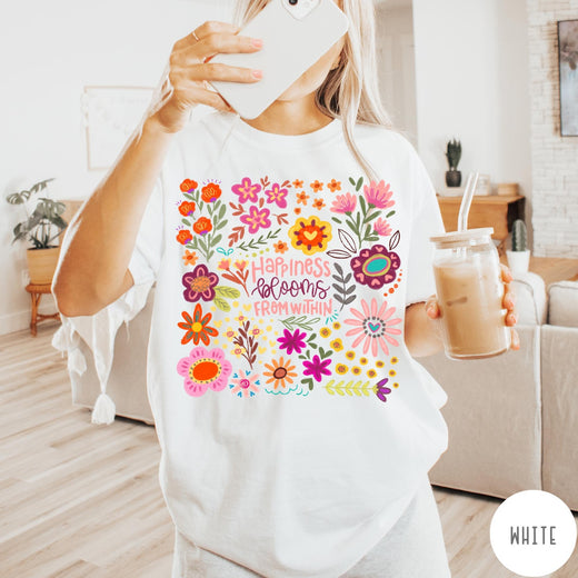 Comfort Colors tee in White featuring floral wildflowers design with Happiness Blooms Within text graphic description