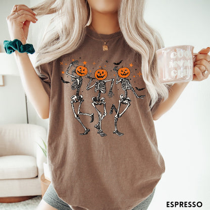 Comfort Colors tee in Espresso featuring dancing skeleton graphic with jack-o'-lantern heads and small orange stars