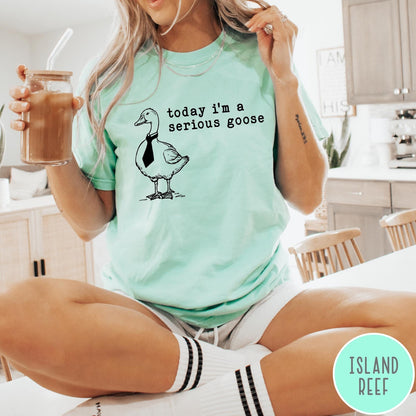 Comfort Colors tee in Island Reef featuring minimalist graphic design of a goose wearing a necktie and text