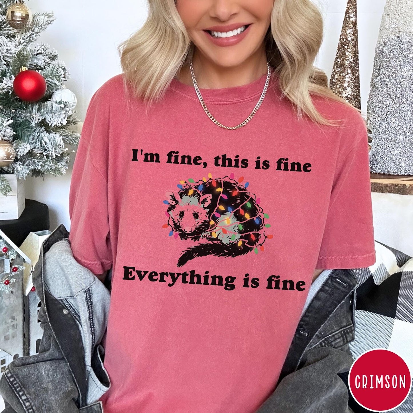 Comfort Colors tee in Crimson featuring graphic illustration of an opossum tangled in colorful Christmas lights