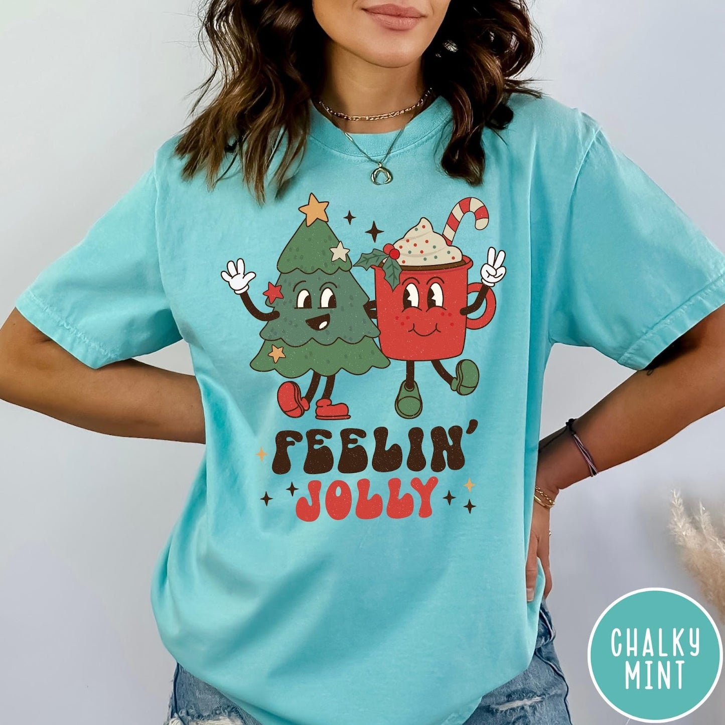 Comfort Colors tee in Chalky Mint featuring retro graphic of a smiling Christmas tree and cocoa mug