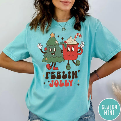 Comfort Colors tee in Chalky Mint featuring retro graphic of a smiling Christmas tree and cocoa mug