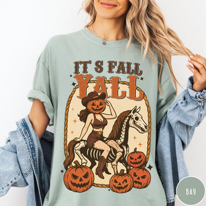 Comfort Colors tee in Bay featuring western graphic of a pumpkin cowgirl riding a skeleton horse with pumpkins