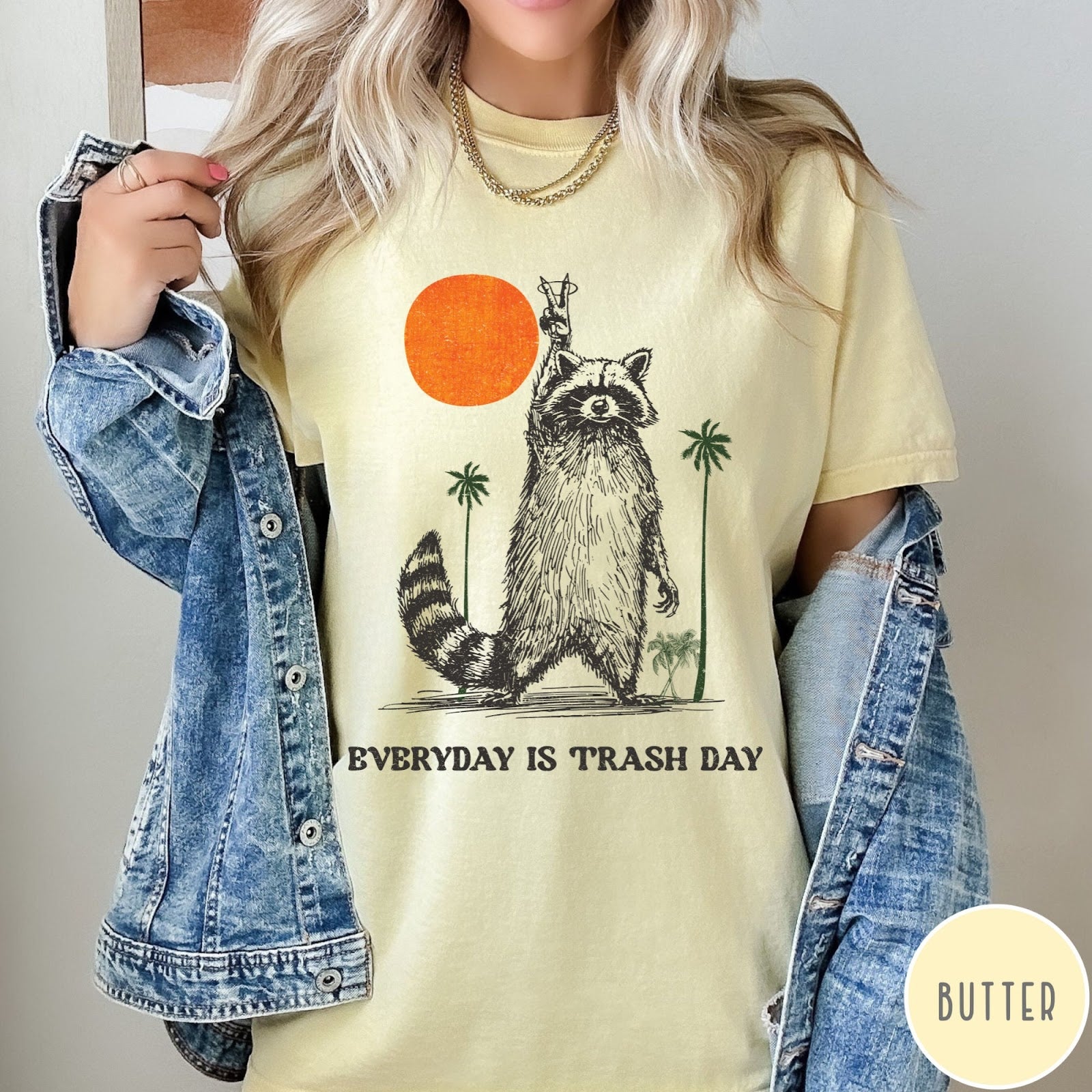 Comfort Colors tee in Butter featuring vintage style graphic of a raccoon making a peace sign