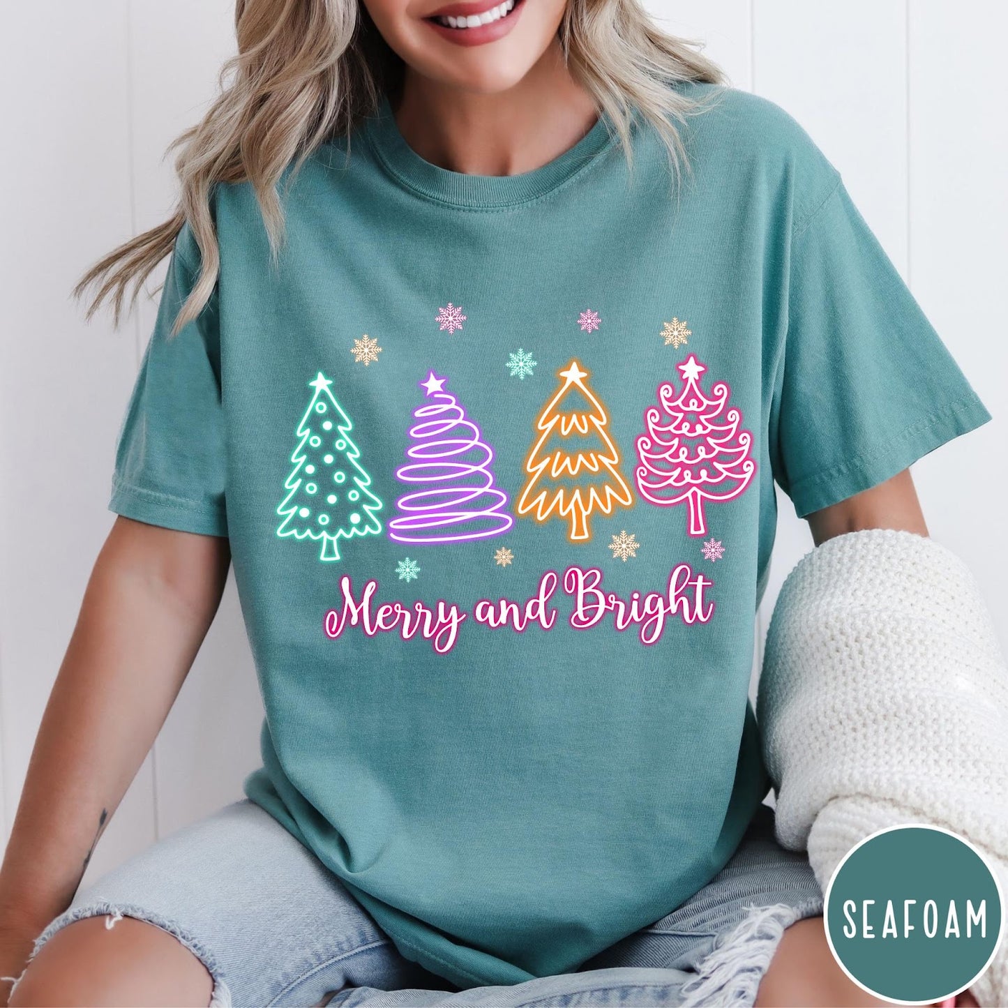 Comfort Colors tee in Seafoam featuring neon Christmas tree graphic with Merry and Bright text and snowflakes