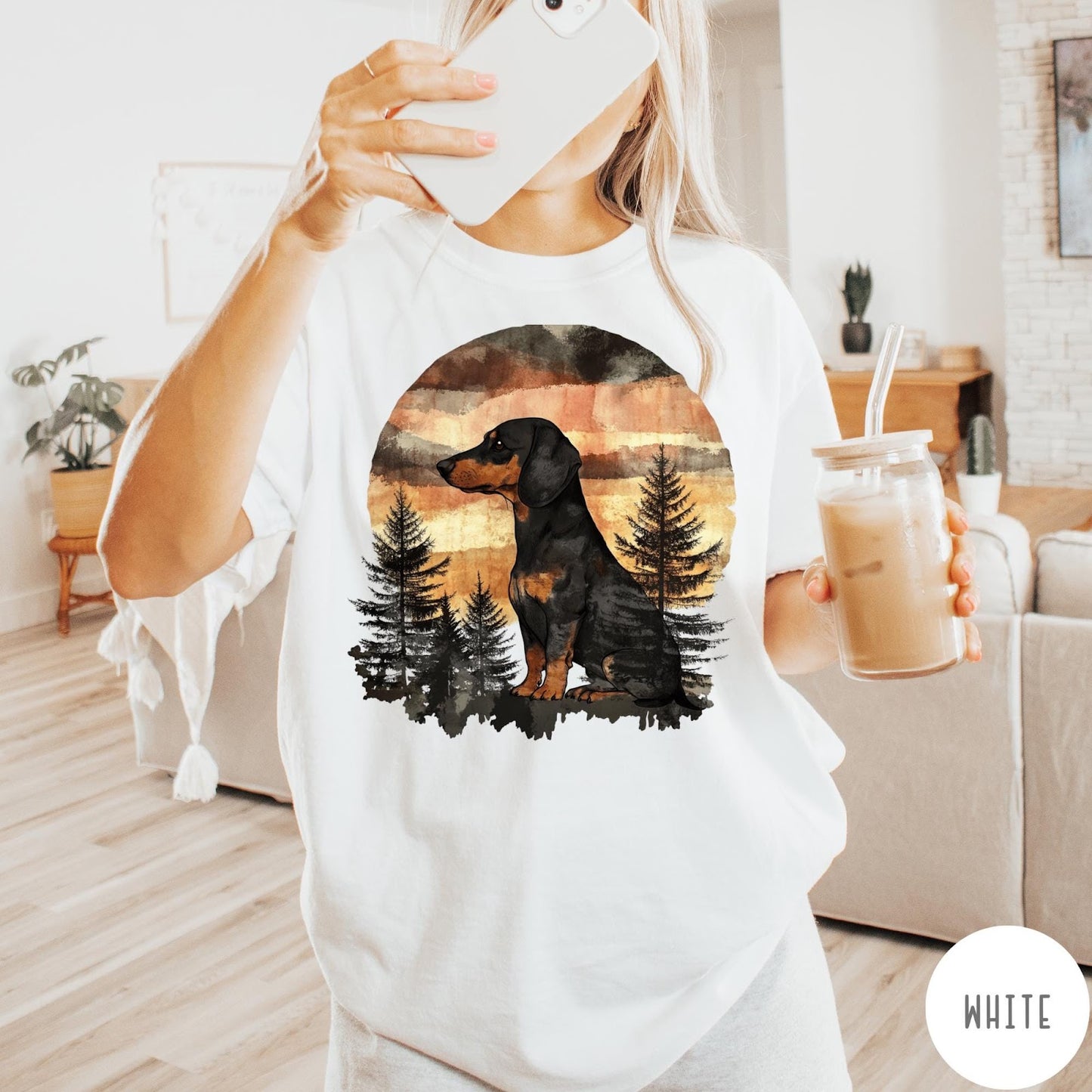 Comfort Colors tee in White featuring vintage style graphic of a dachshund sitting in a forest sunset