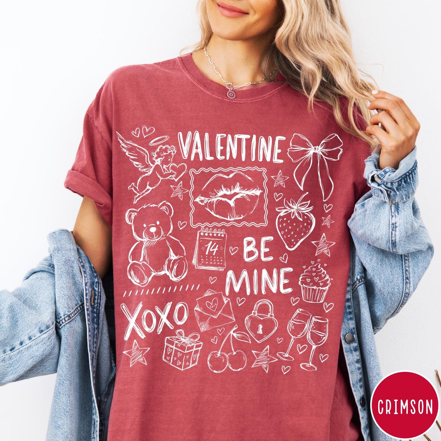 Comfort Colors tee in Crimson featuring sketch style Valentine's Day collage graphic with cupid, bear, and hearts