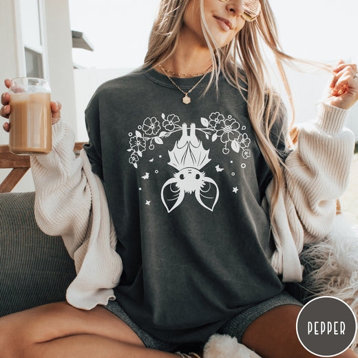 Comfort Colors tee in Pepper featuring line art style upside down bat graphic with surrounding floral elements