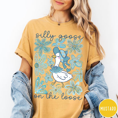 Comfort Colors tee in Mustard featuring whimsical graphic style with a goose wearing a bonnet and floral border