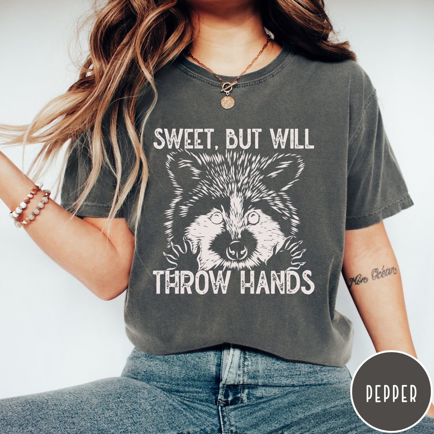 Comfort Colors tee in Pepper featuring graphic style raccoon illustration with text Sweet But Will Throw Hands
