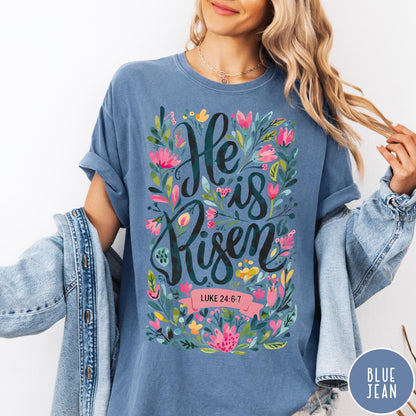 Comfort Colors tee in Blue Jean featuring religious floral design with He is Risen text graphic