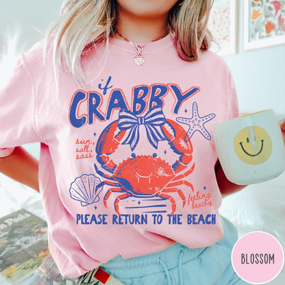 Comfort Colors tee in Blossom featuring coastal graphic design with a crab, bow, starfish, and beach text