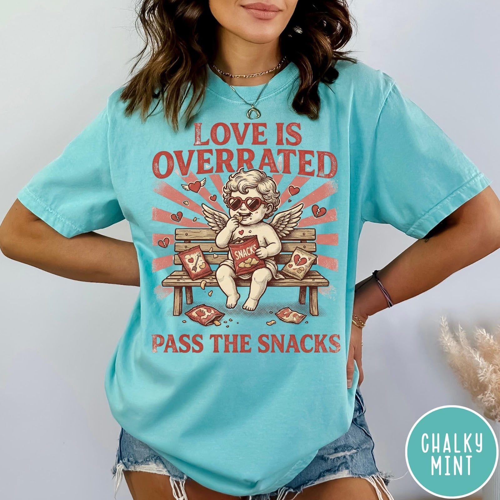Comfort Colors tee in Chalky Mint featuring vintage style graphic of a cherub eating snacks on a bench