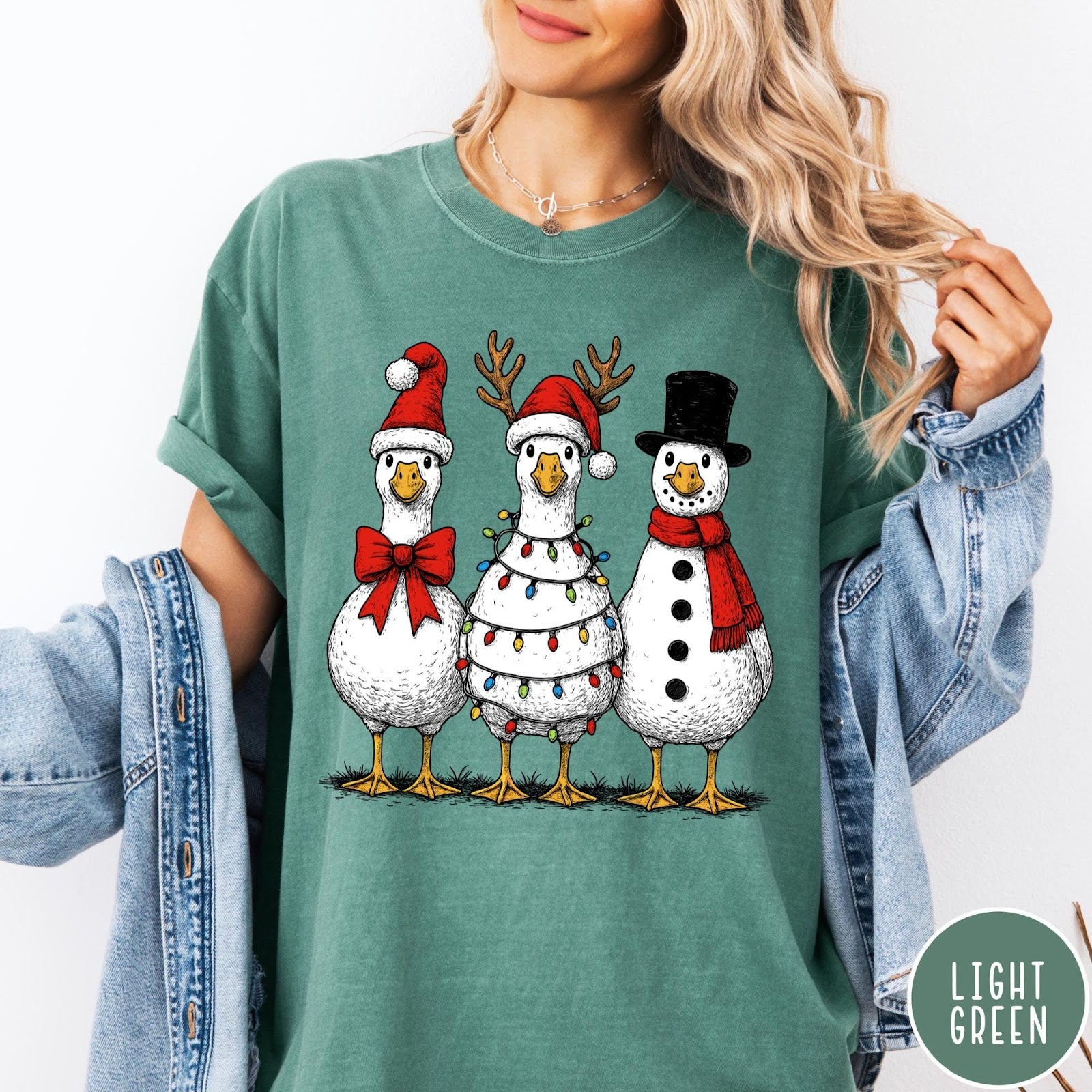 Comfort Colors tee in Light Green featuring festive holiday graphic of three geese dressed as Santa and snowman