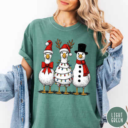 Comfort Colors tee in Light Green featuring festive holiday graphic of three geese dressed as Santa and snowman