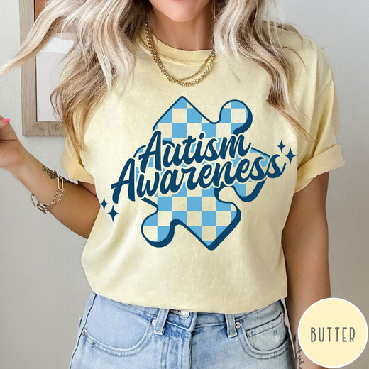 Comfort Colors tee in Butter featuring casual style with a blue checkered puzzle piece Autism Awareness graphic