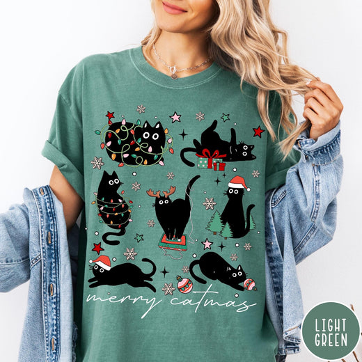 Comfort Colors tee in Light Green featuring festive holiday graphic with multiple black cats and Christmas elements
