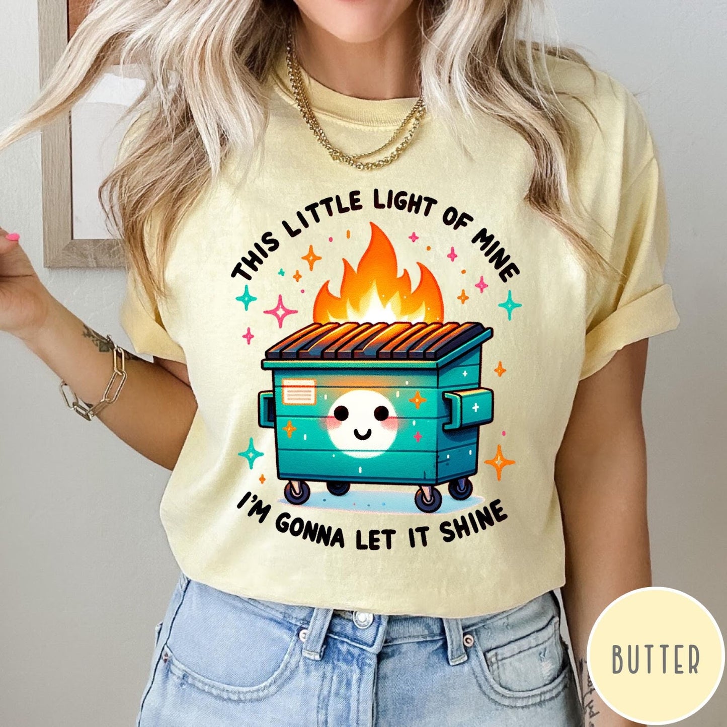 Comfort Colors tee in Butter featuring cartoon style graphic of a smiling dumpster fire with text