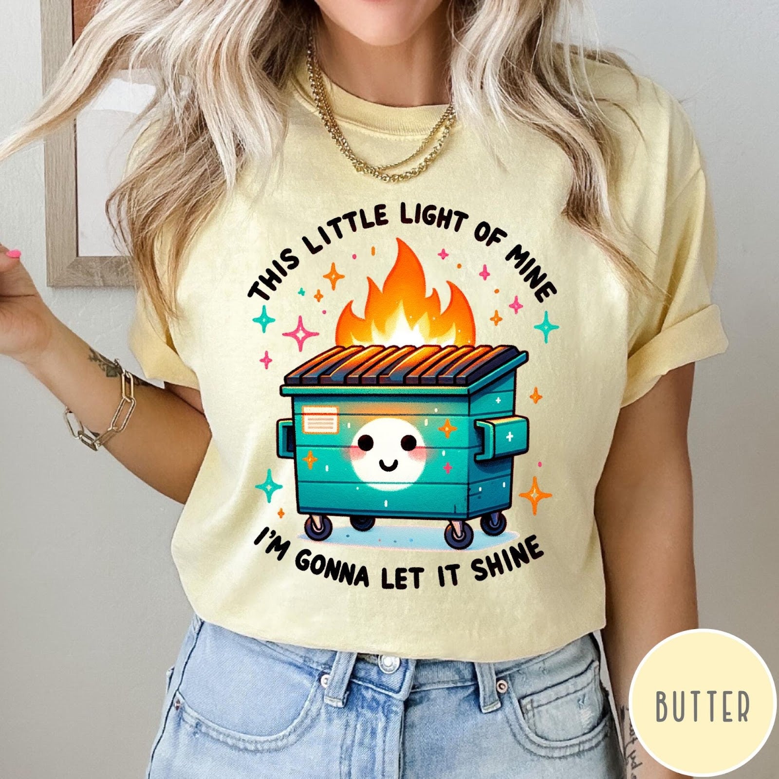 Comfort Colors tee in Butter featuring cartoon style graphic of a smiling dumpster fire with text
