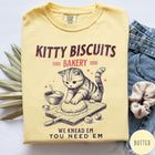 Comfort Colors tee in Butter featuring vintage style graphic of a cute cat kneading dough for biscuits