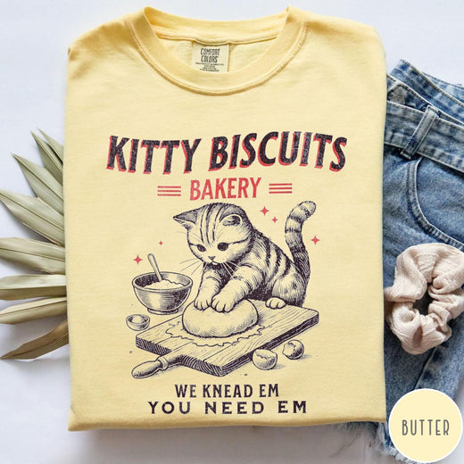 Comfort Colors tee in Butter featuring vintage style graphic of a cute cat kneading dough for biscuits