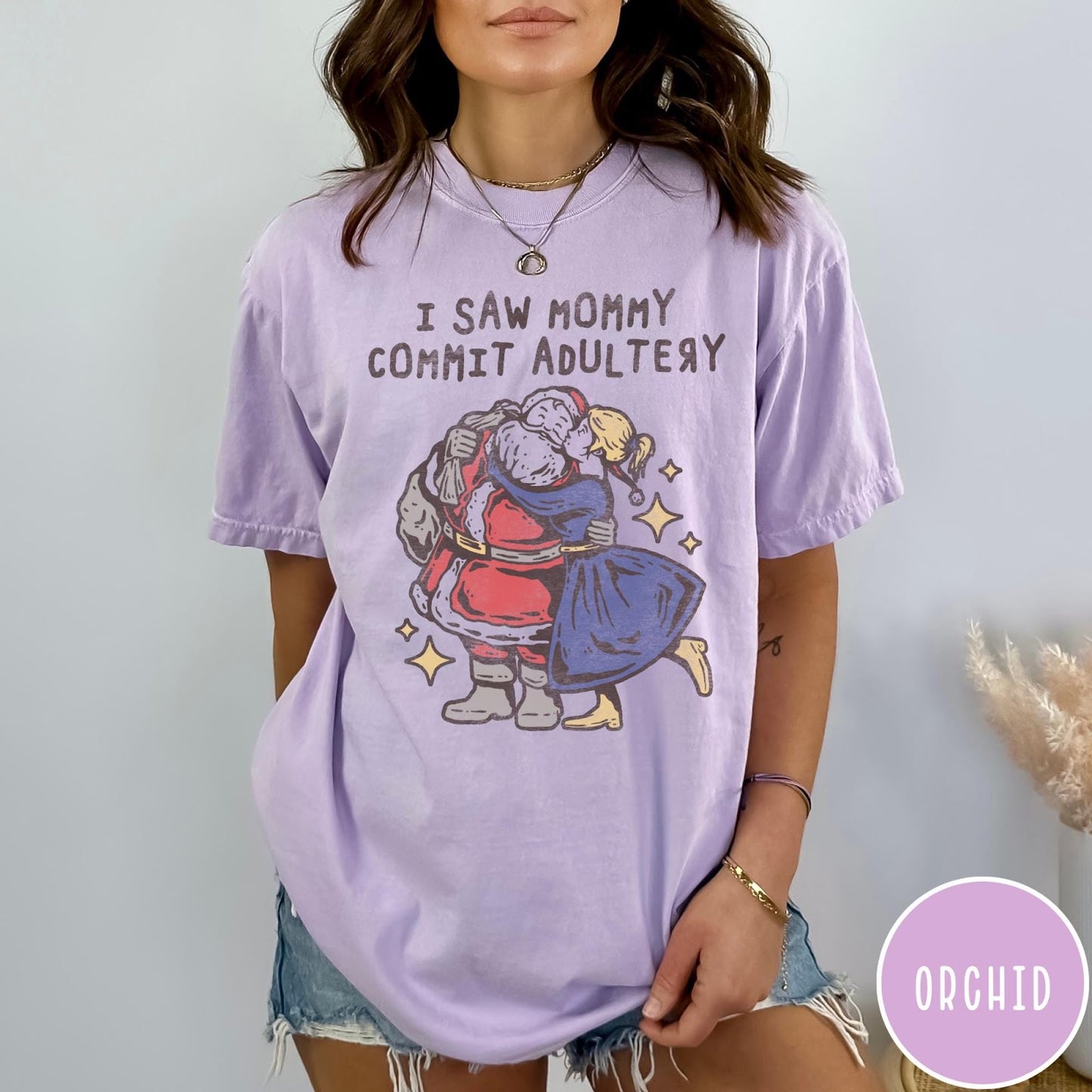 Comfort Colors tee in Orchid featuring vintage style graphic of Santa Claus kissing a woman under stars