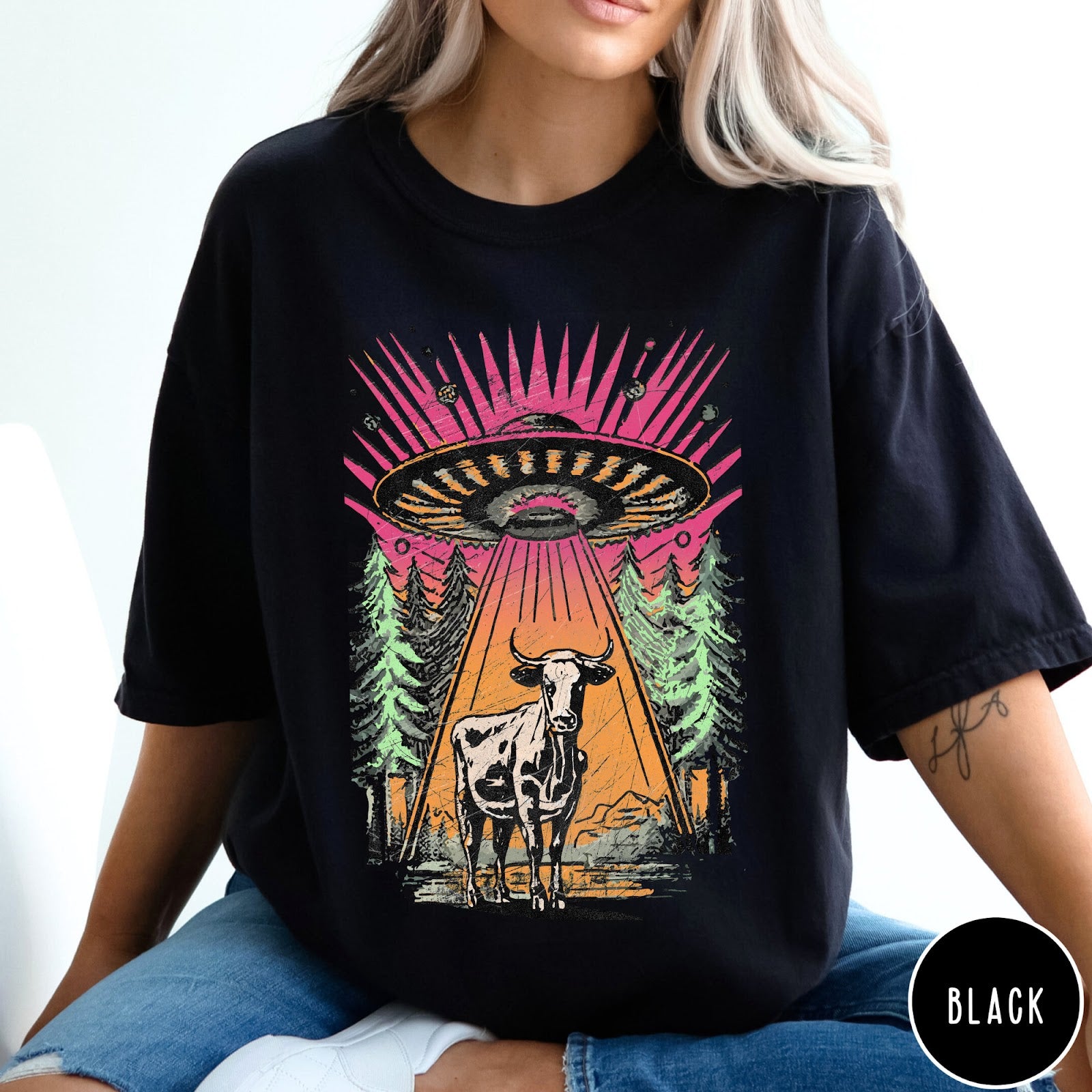 Comfort Colors tee in Black featuring graphic style cow being abducted by a UFO in the forest