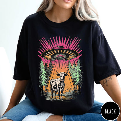 Comfort Colors tee in Black featuring graphic style cow being abducted by a UFO in the forest