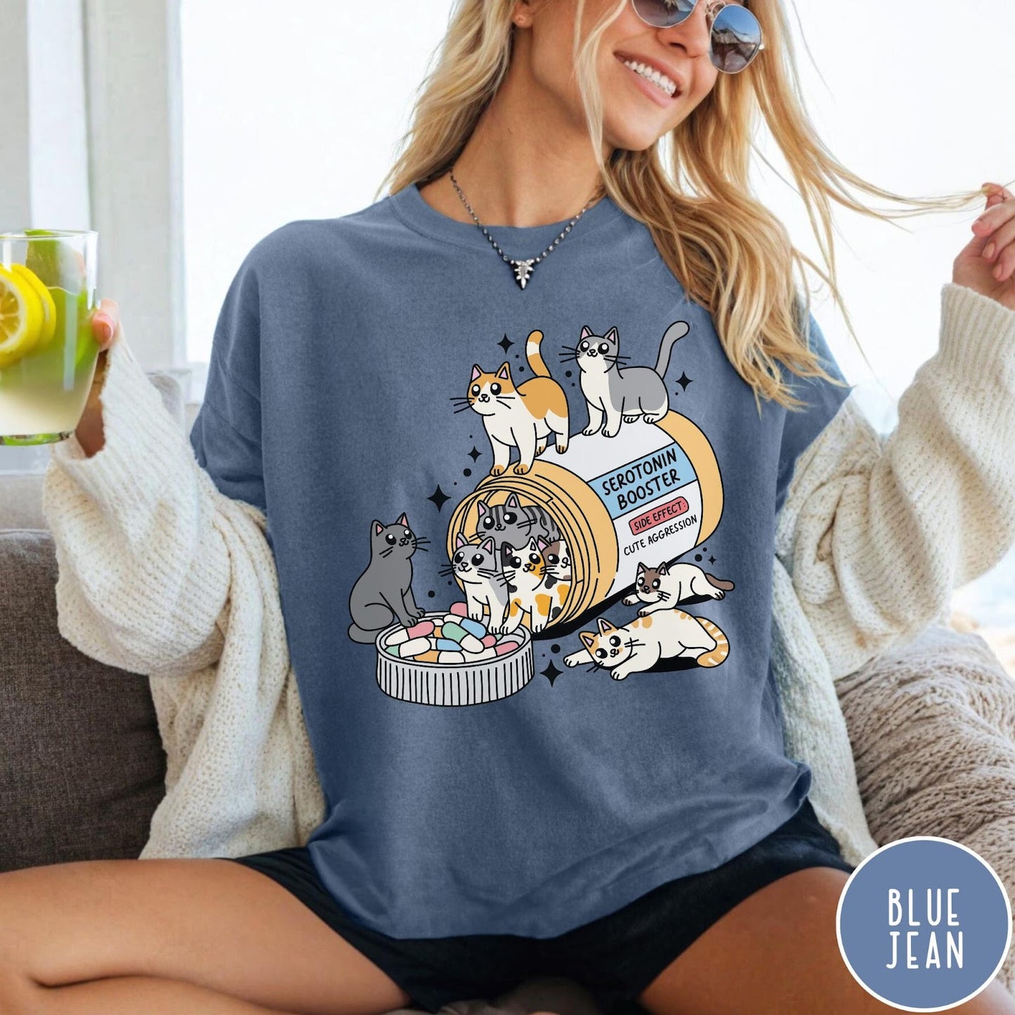Comfort Colors tee in Blue Jean featuring graphic illustration of cats spilling out of a serotonin booster bottle