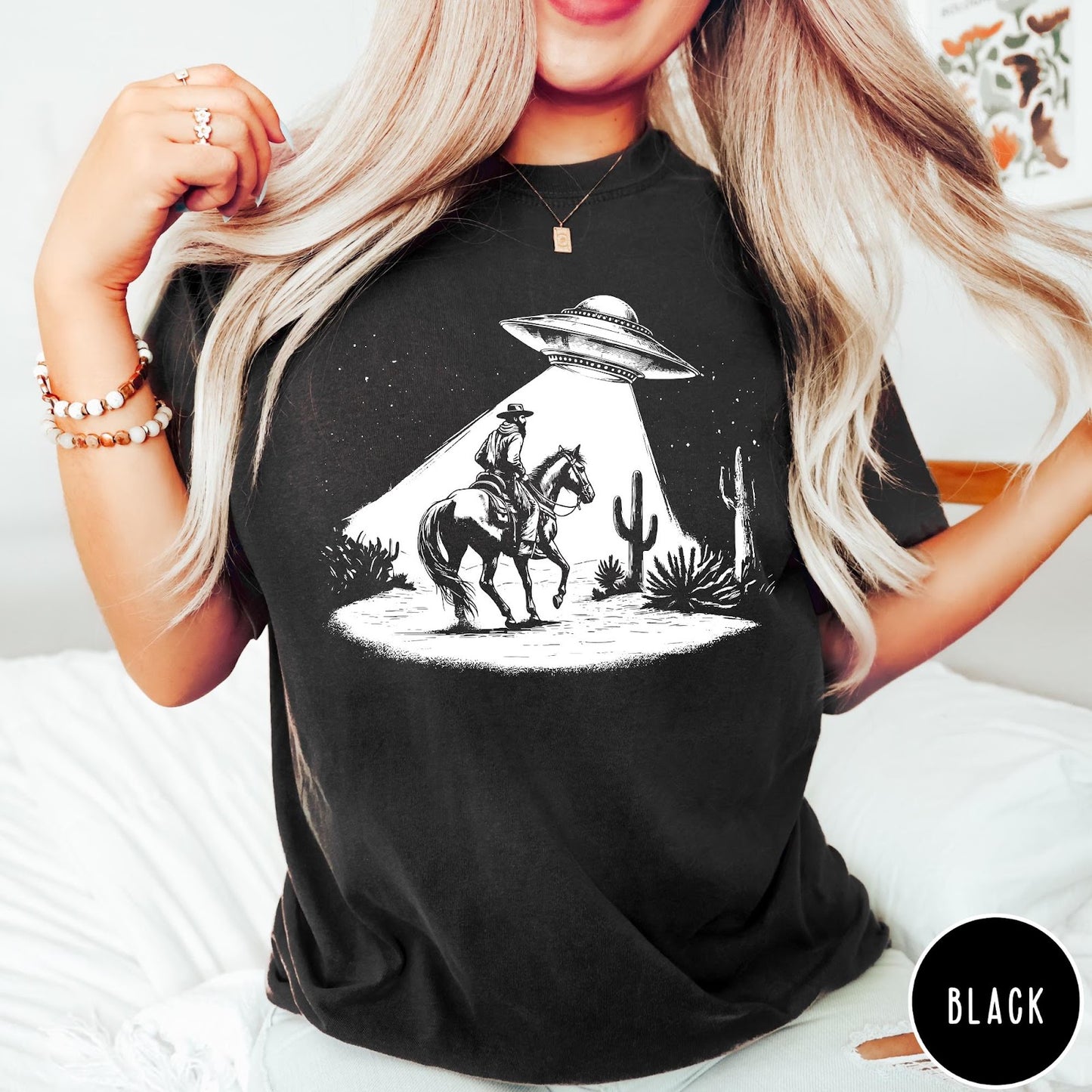 Comfort Colors tee in Black featuring western graphic style cowboy on horseback being abducted by a UFO