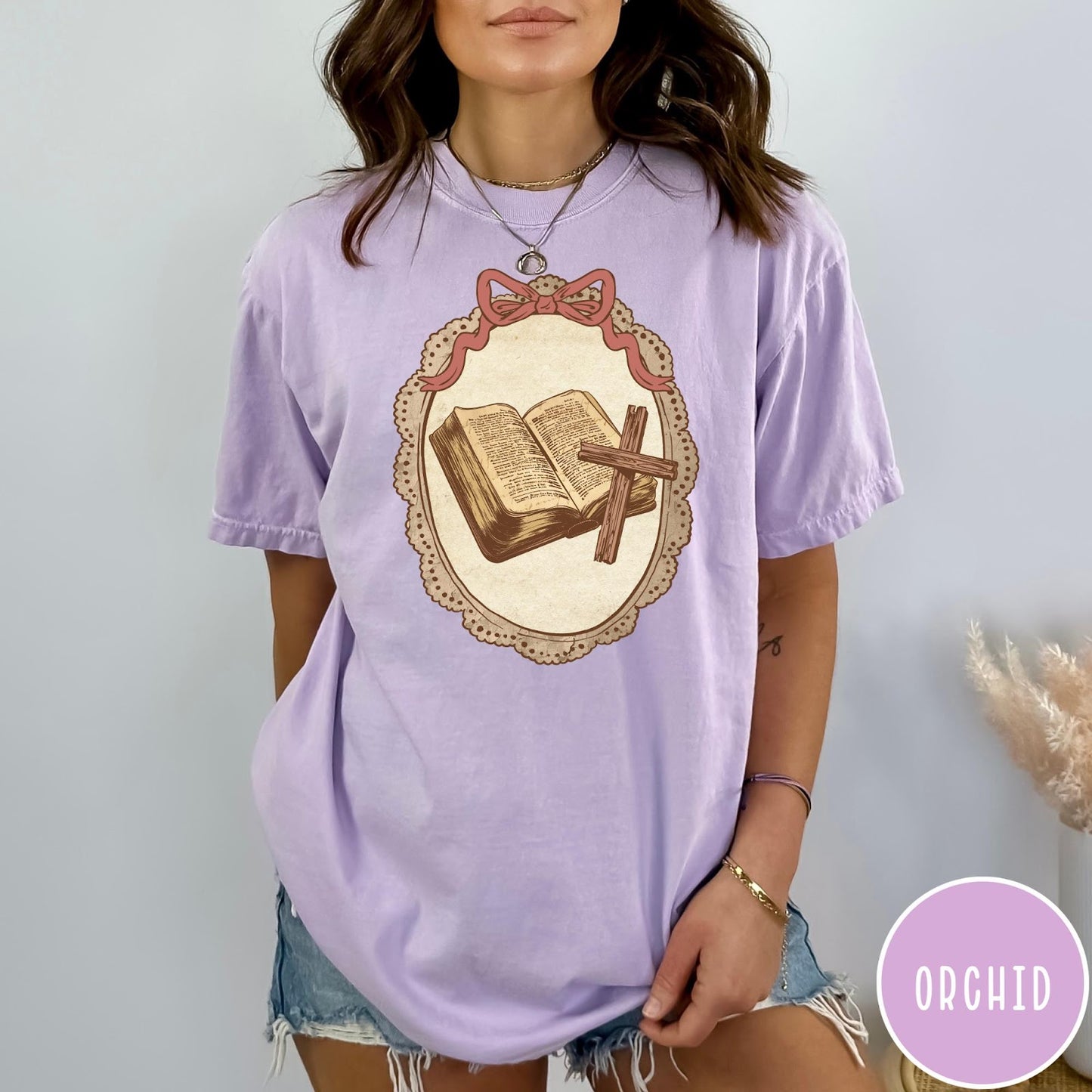Comfort Colors tee in Orchid featuring vintage style graphic of an open Bible and wooden cross