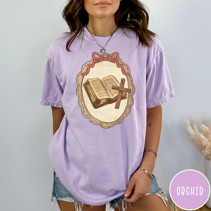 Comfort Colors tee in Orchid featuring vintage style graphic of an open Bible and wooden cross