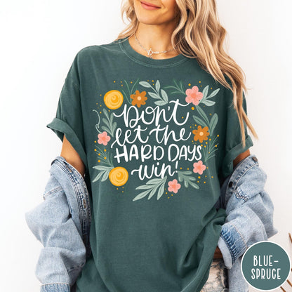 Comfort Colors tee in Blue Spruce featuring floral design with mental health encouragement text Don't Let The Hard Days Win