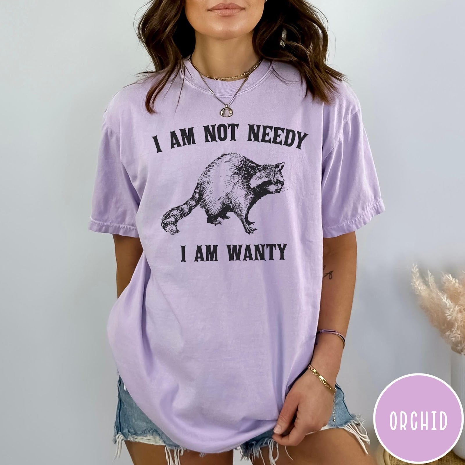 Comfort Colors tee in Orchid featuring vintage style graphic of a raccoon with text I Am Not Needy