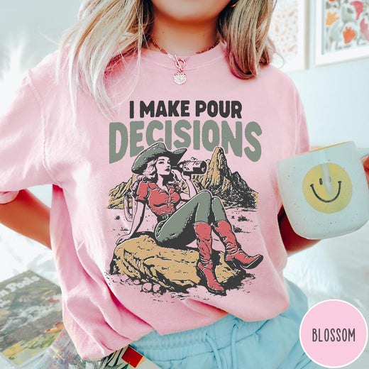 Comfort Colors tee in Blossom featuring western style graphic of a cowgirl sitting on a rock drinking