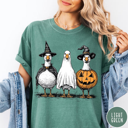 Comfort Colors tee in Light Green featuring Halloween graphic with three geese dressed as a witch, ghost, and pumpkin