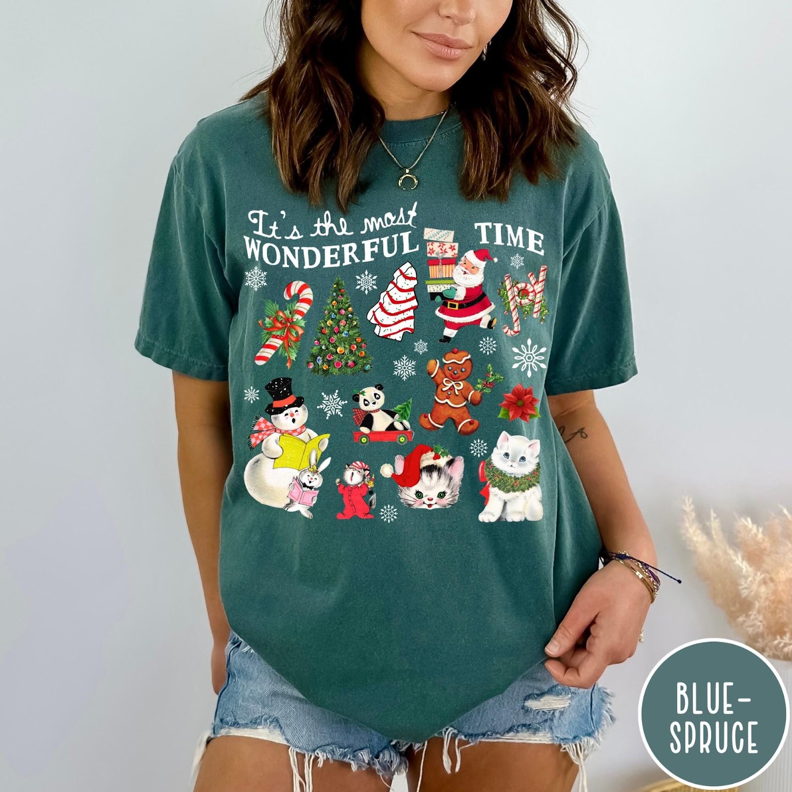 Comfort Colors tee in Blue Spruce featuring Christmas collage graphic with Santa, snowman, animals, and holiday icons
