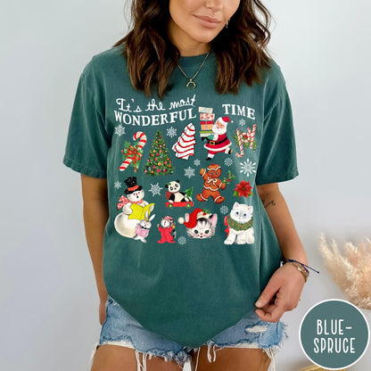 Comfort Colors tee in Blue Spruce featuring Christmas collage graphic with Santa, snowman, animals, and holiday icons