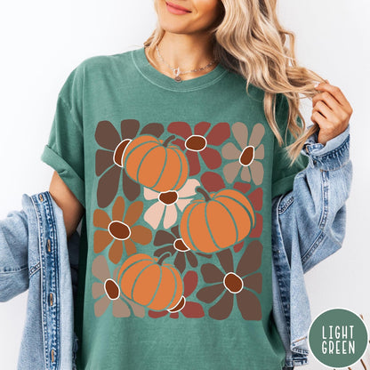 Comfort Colors tee in Light Green featuring boho floral style graphic with three orange pumpkins and brown flowers