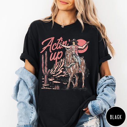 Comfort Colors tee in Black featuring western style graphic of a cowgirl riding a horse in the desert