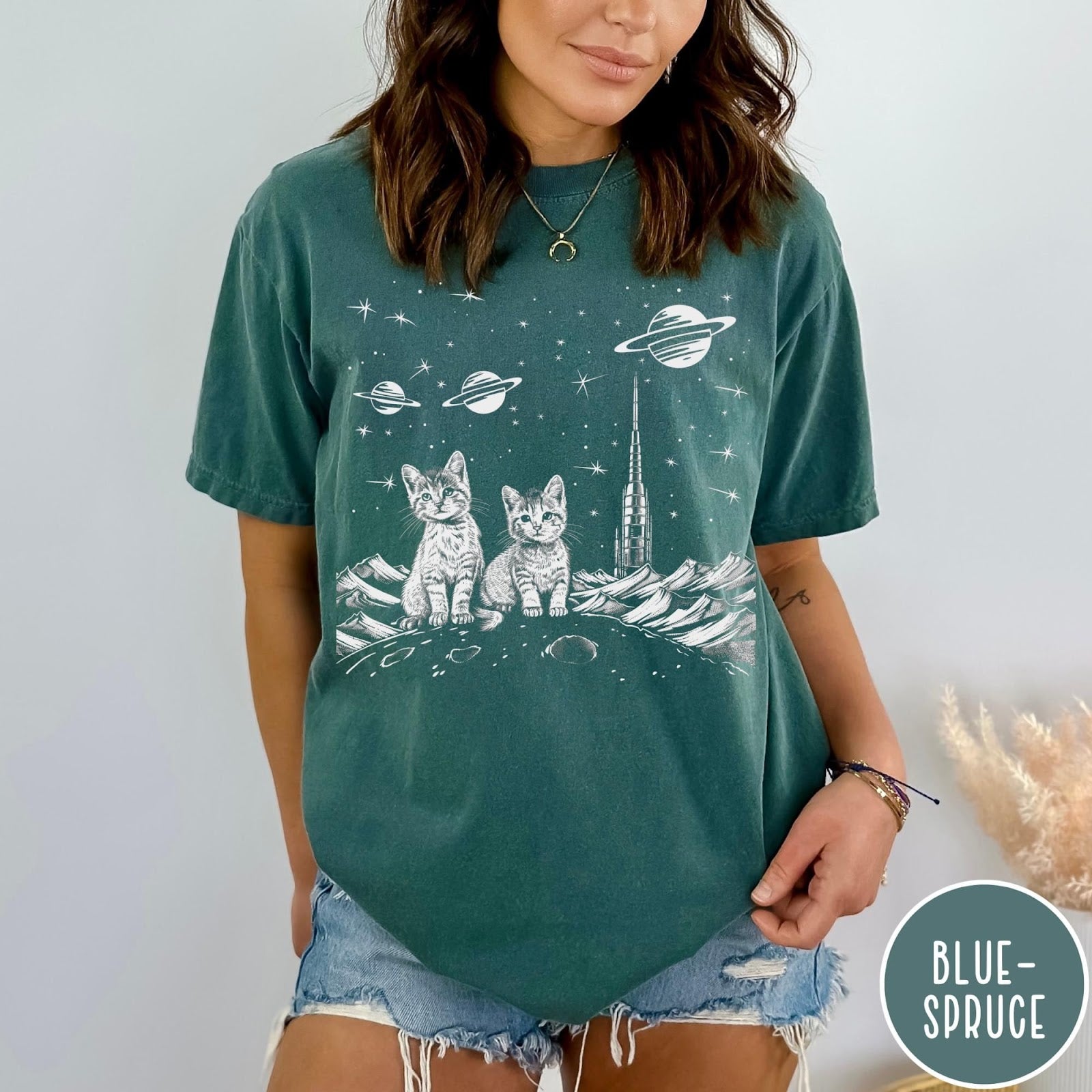 Comfort Colors tee in Blue Spruce featuring line art graphic of two kittens sitting on a planet with rocket